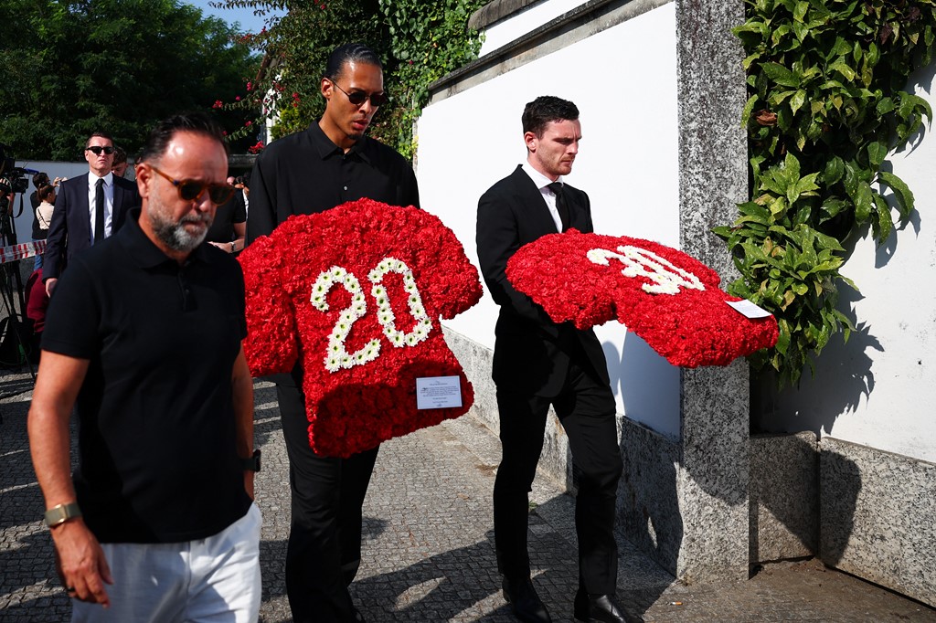 Van Dijk and Robertson carrying floral tributes