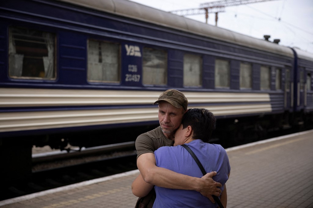 A soldier bids farewell to his partner as she joins others fleeing the Russian advance