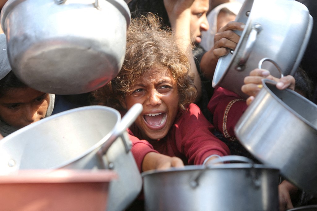 A child trying to get food in Gaza in August