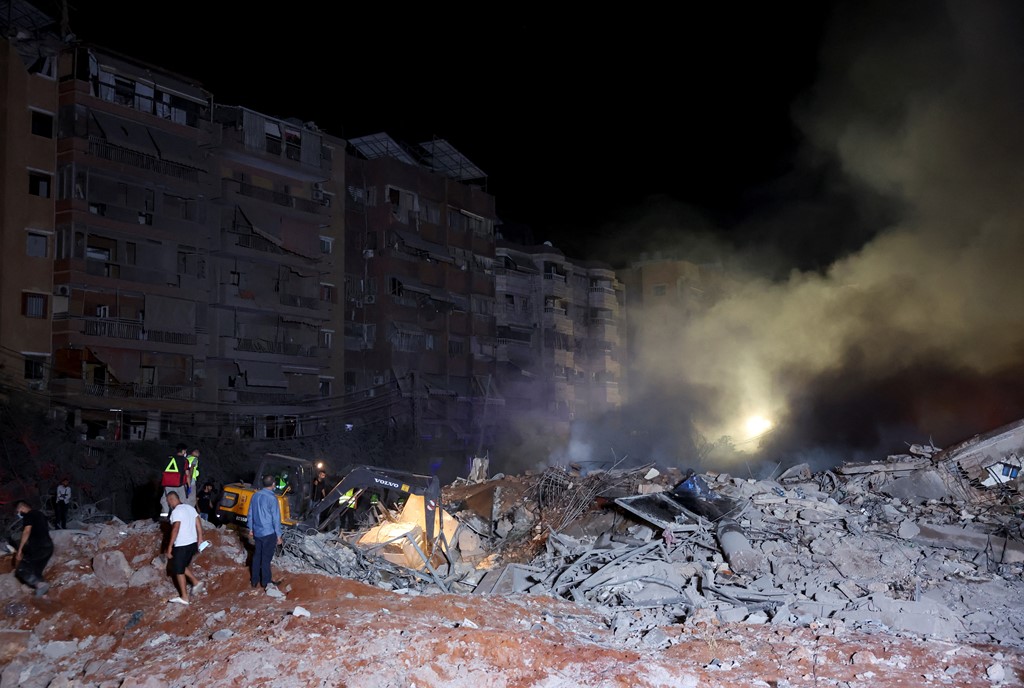 People inspecting the damage after an Israeli strike in Beirut