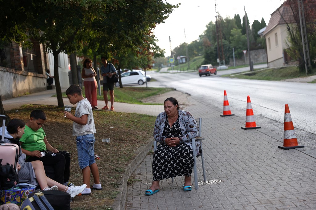 A Ukrainian woman of Roma ethnicity sits on a chair on the street after losing access to her accommodation in Kocs, Hungary
