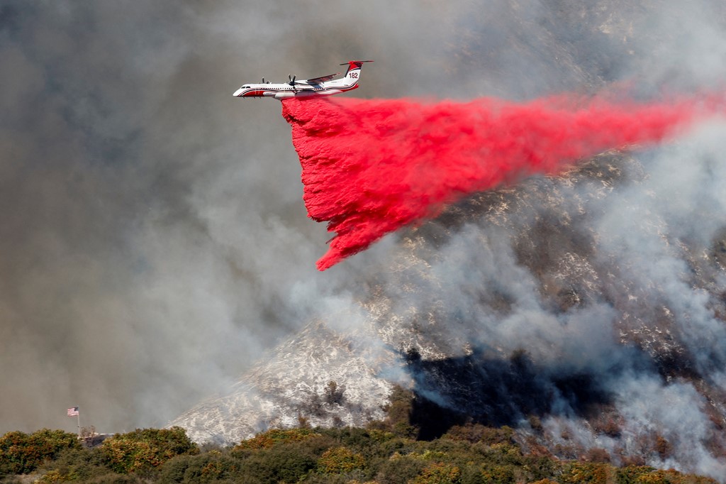 A plane makes a fire retardant drop