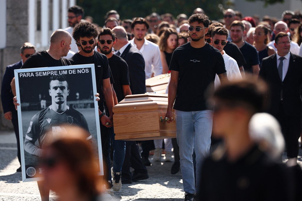 Pallbearers carry the coffins in procession