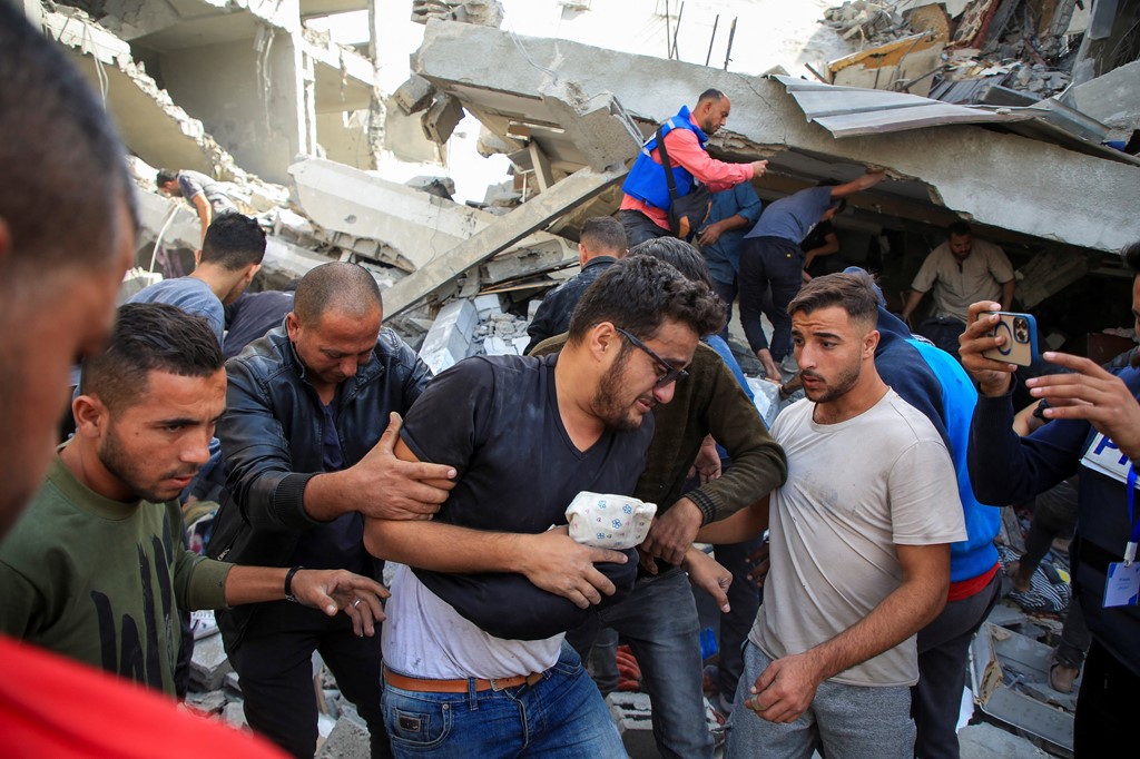 A man helped after an Israeli strike on a house in Gaza City