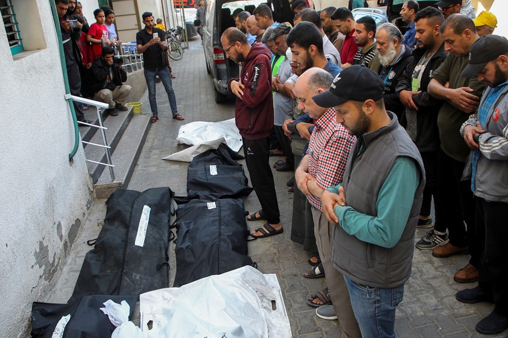 Mourners pray next to the bodies of Palestinians killed in Rafah