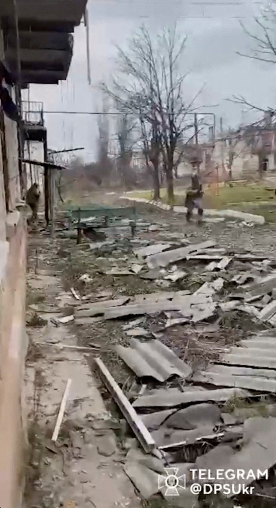 一名士兵在索莱达尔受损建筑物的废墟中奔跑