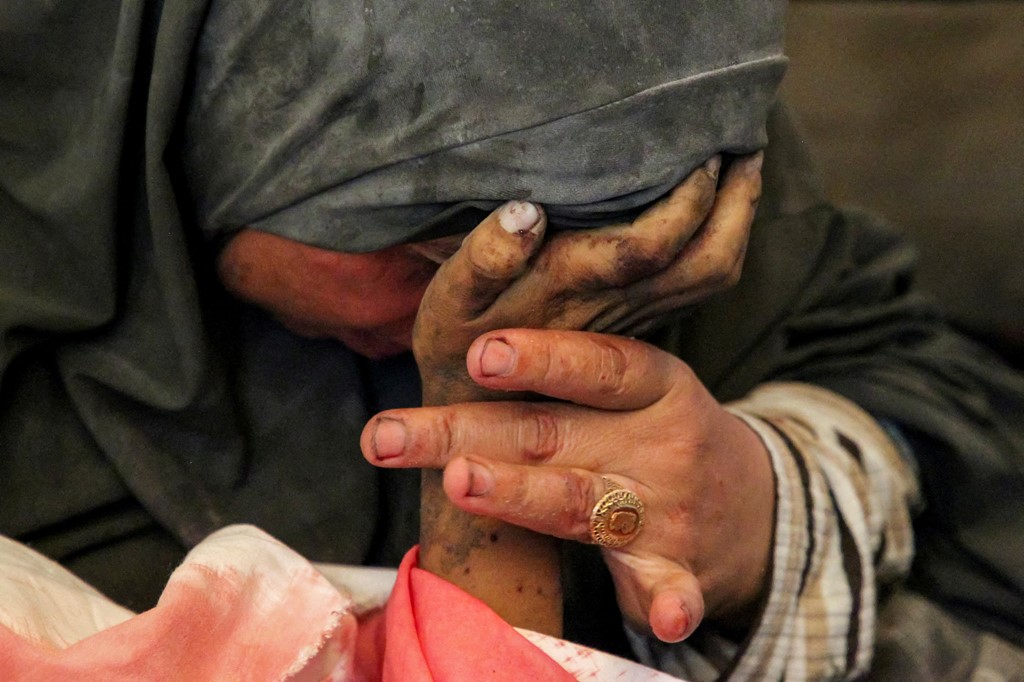 Buthayna Abu Jazar cradles the hand of her son Hazma, who was killed in an Israeli strike on Rafah