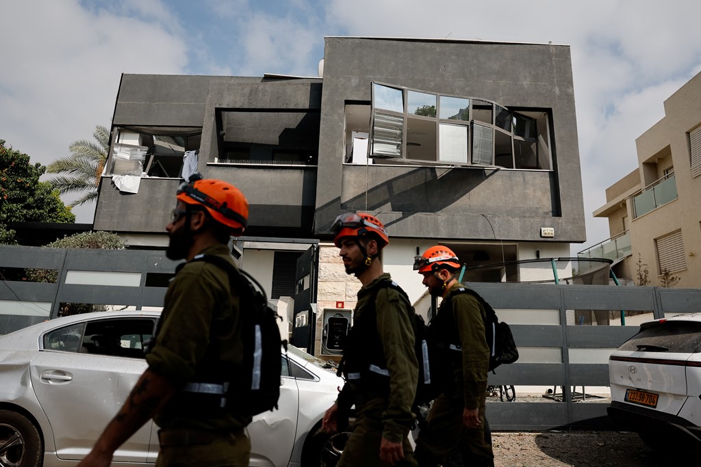 Israeli forces in front of a building hit by a missile