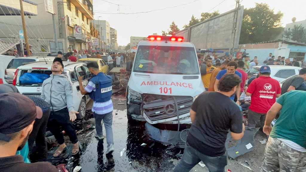 Palestinians check the damage after a convoy of ambulances was hit near the al Shifa hospital on 3 November 