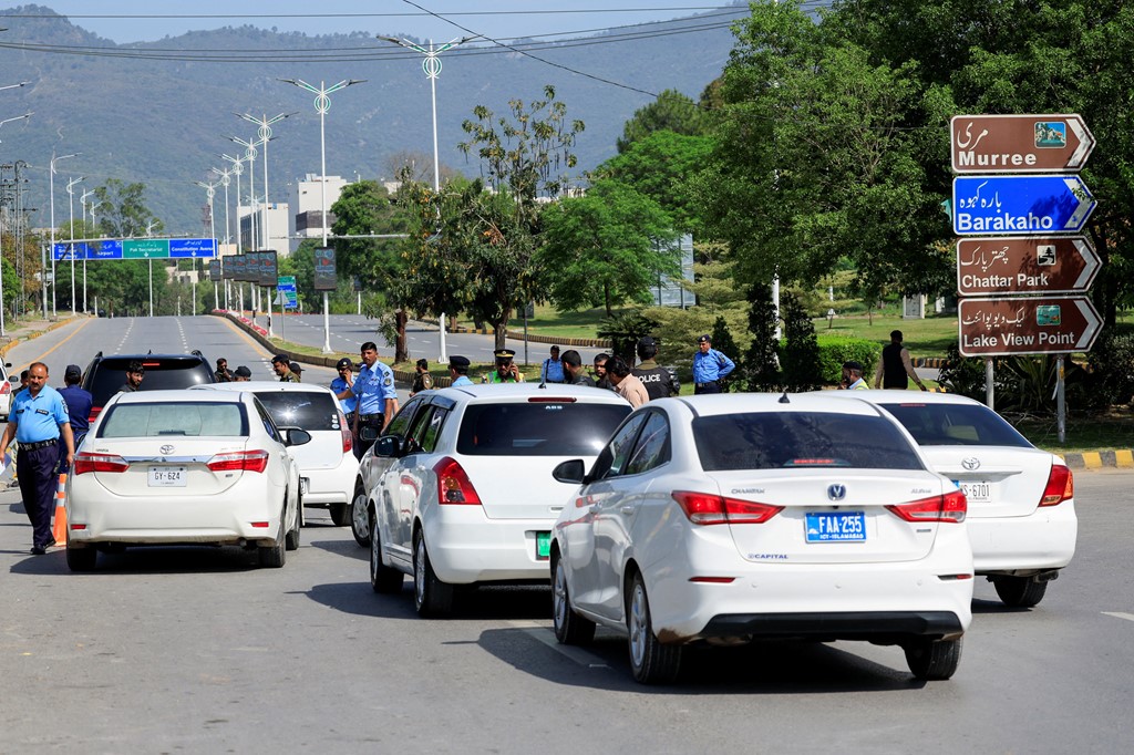 Police stand guard on a road leading to the Serena Hotel, in Islamabad